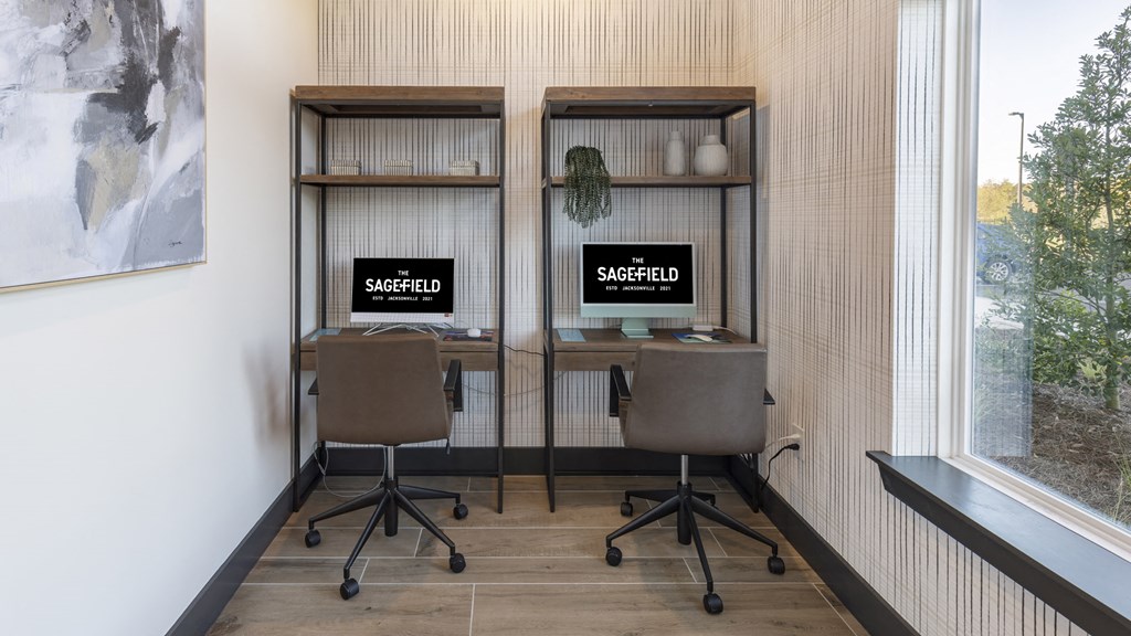 two desks with computers in a room with a window