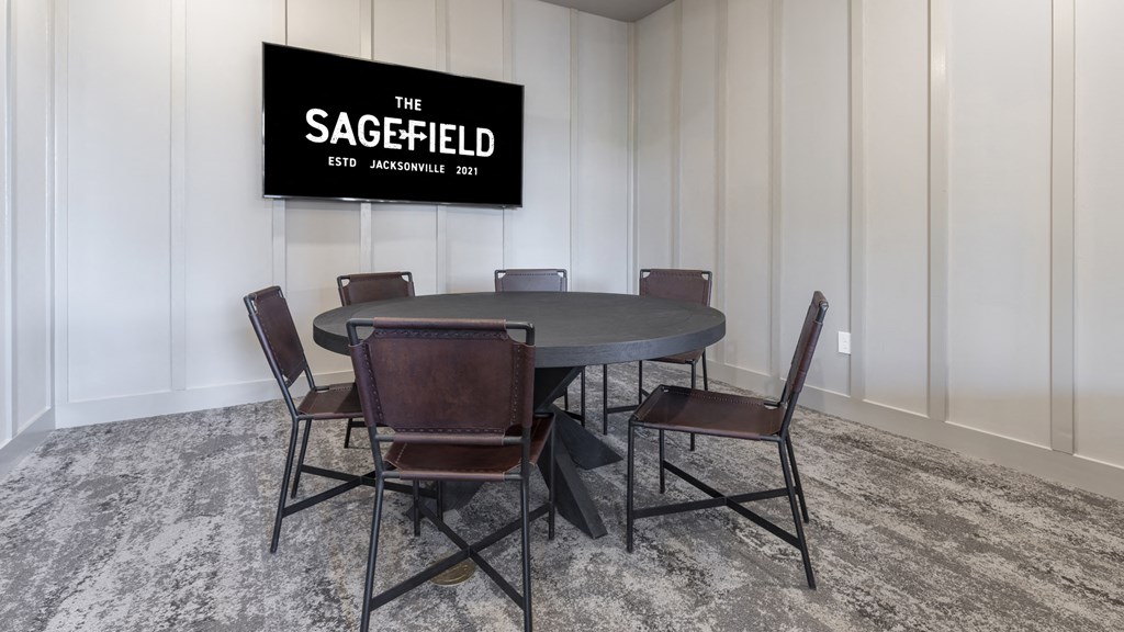 a conference room with a round table and a tv on the wall