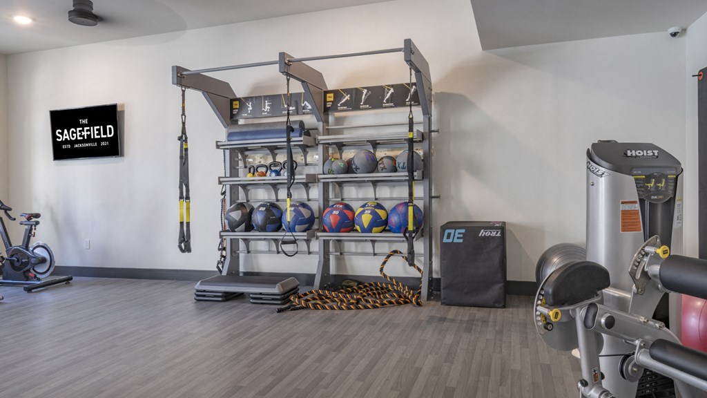 a gym with weights and other exercise equipment in a building with white walls