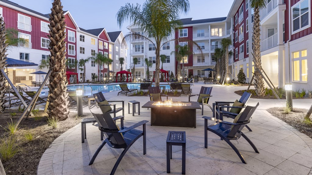 an outdoor courtyard with tables and chairs at an apartment complex