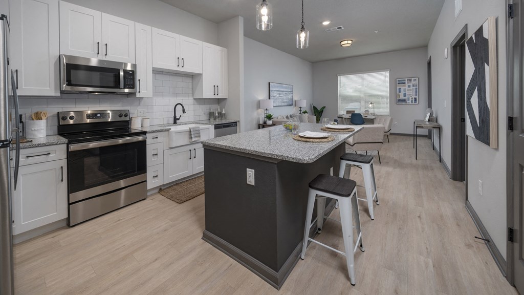 an open kitchen and dining area with stainless steel appliances and a granite counter top