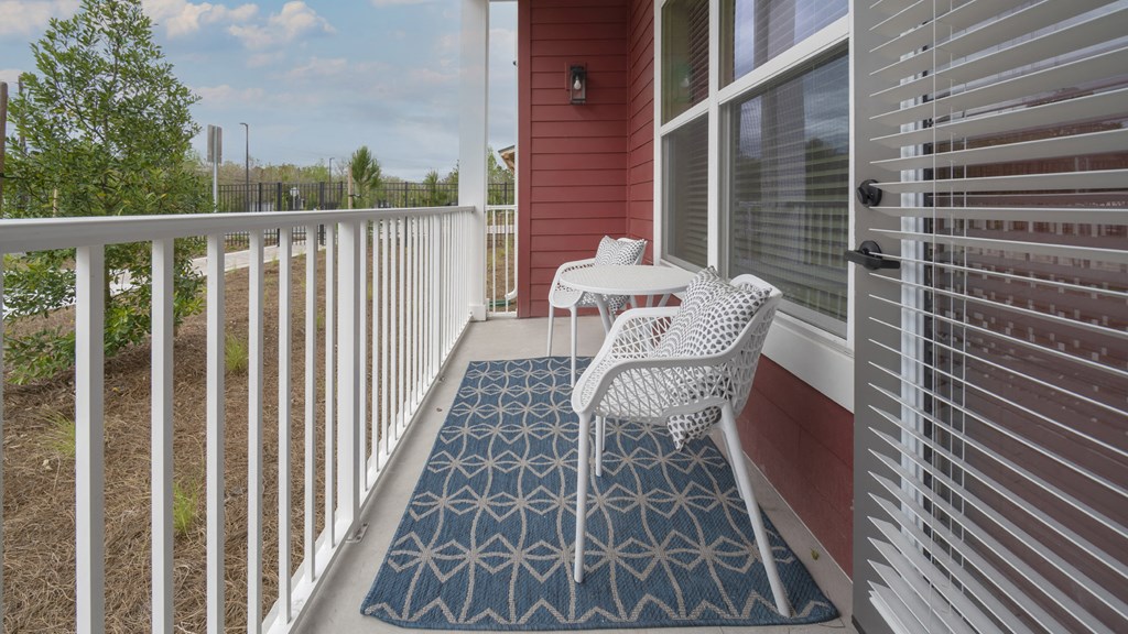a patio with two chairs and a table on a balcony