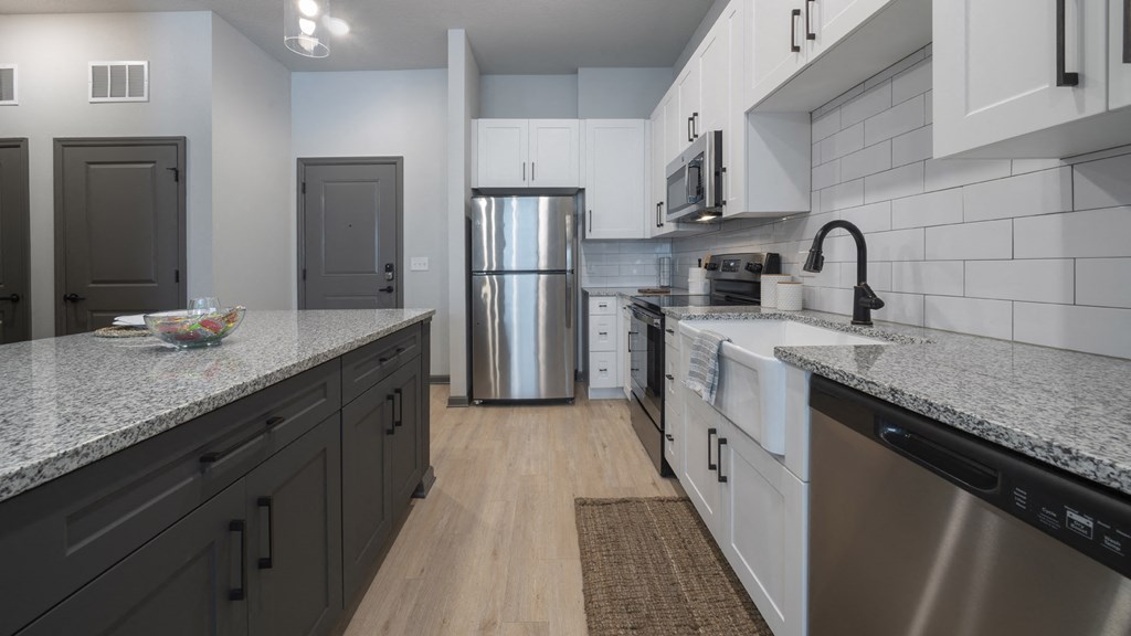 a kitchen with granite counter tops and stainless steel appliances