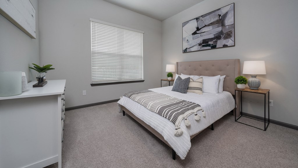 an empty bedroom with a bed and a window