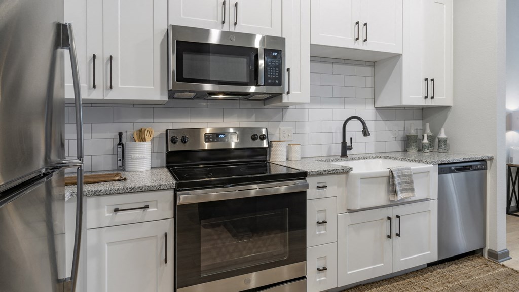 a kitchen with stainless steel appliances and white cabinets