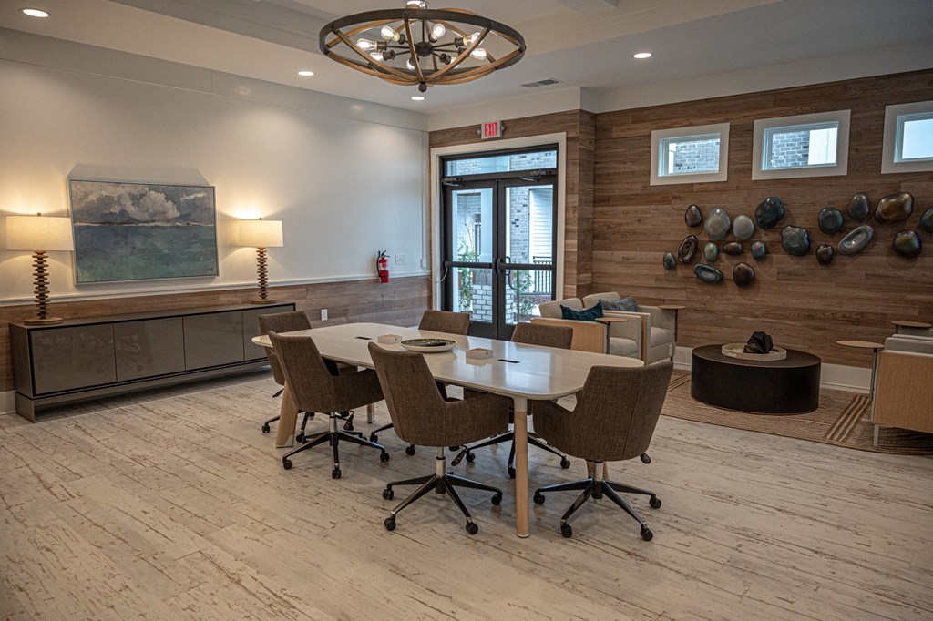 A conference room with a long table surrounded by chairs.
