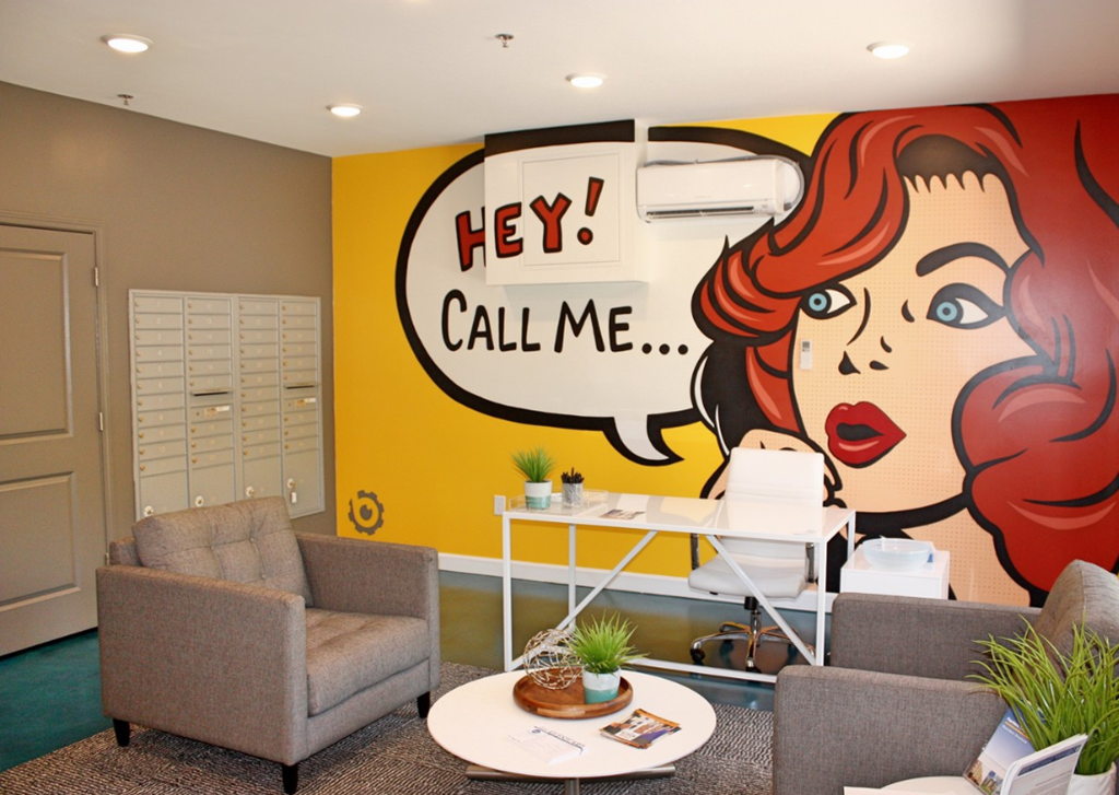 a office with a wall mural of a woman saying call me