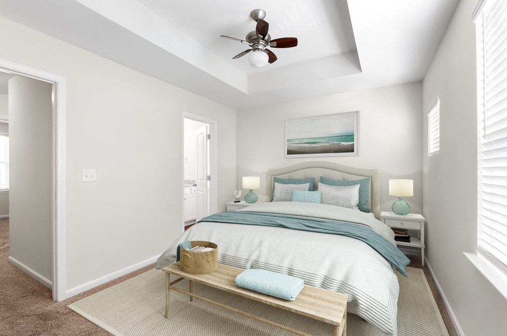 A bedroom with a bed, nightstands, and a ceiling fan.