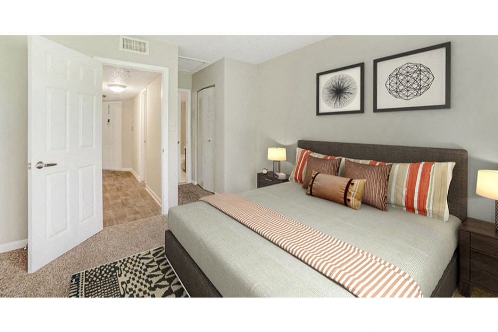 Spacious bedroom with plush carpeting and large window at Midora at Woodmont in Tamarac, FL