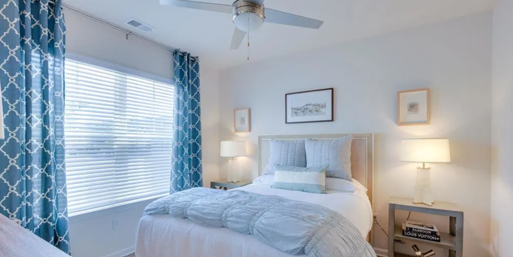 a bedroom with a bed and a ceiling fan