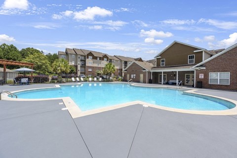 A large swimming pool in front of apartment buildings.