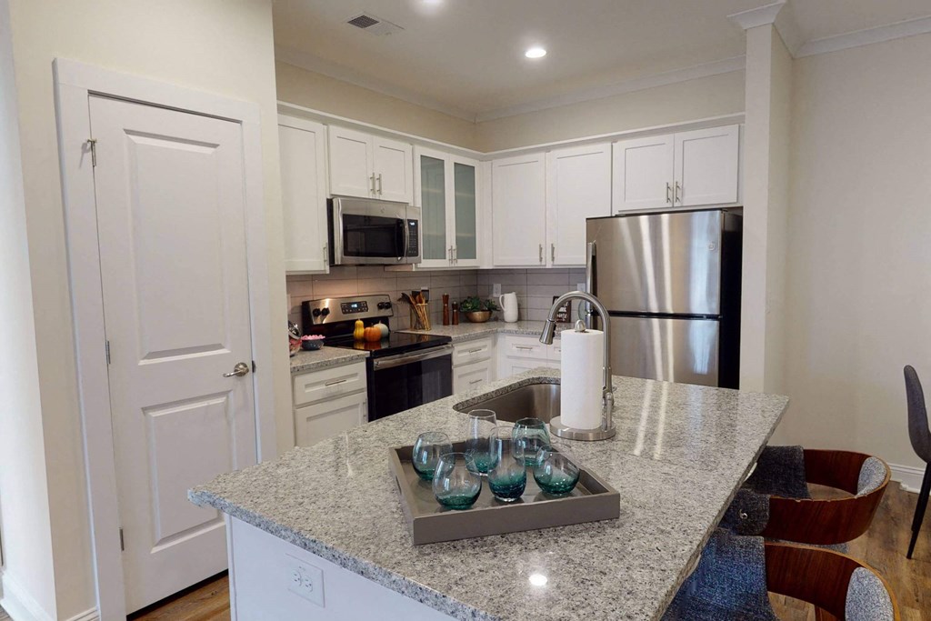 a kitchen with a granite counter top and a stainless steel refrigerator