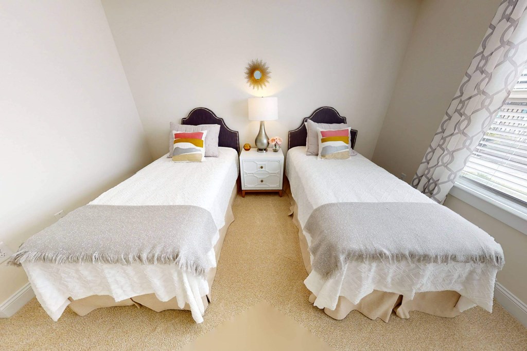 two twin beds in a small room with a window