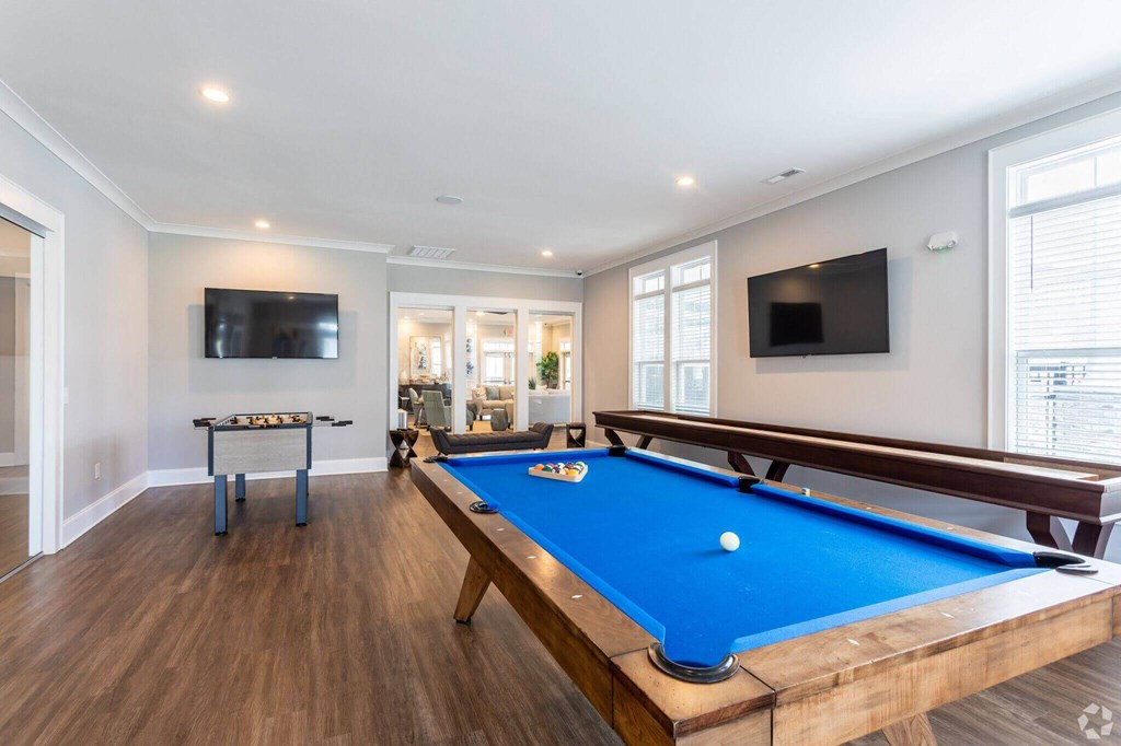 a games room with a pool table and a television