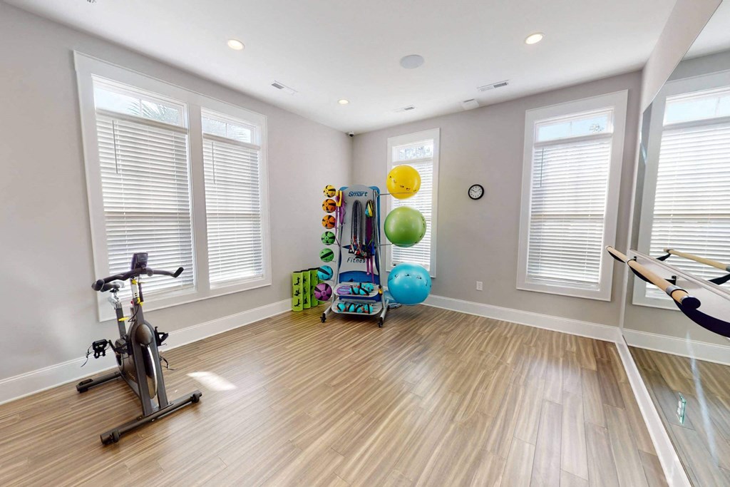 a workout room with a bike and balls in it