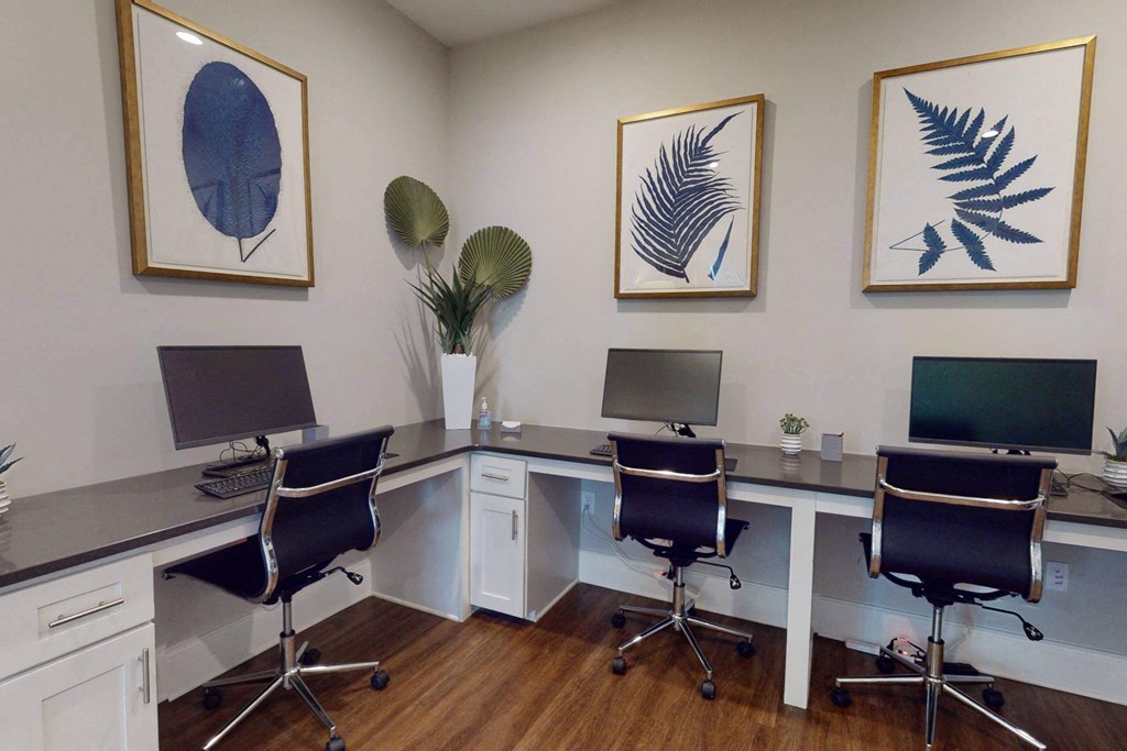 a conference room with two desks and three computers