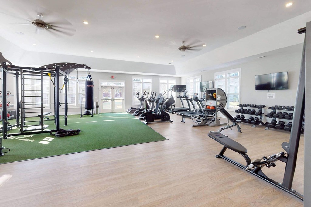 a gym with weights and a tv on the wall