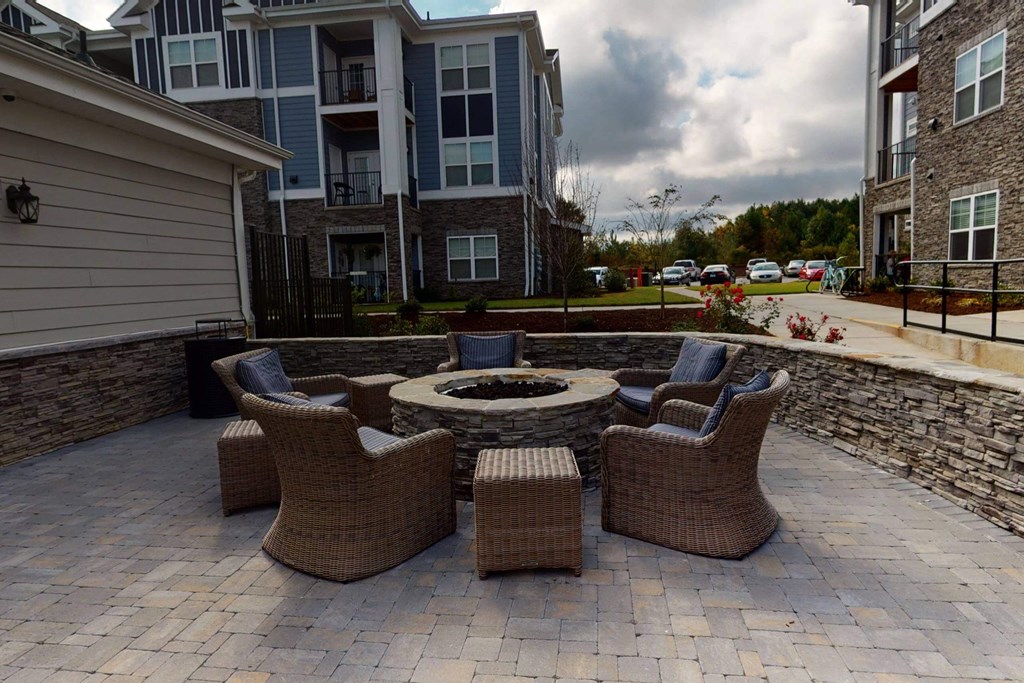 patio with furniture and fire pit in front of an apartment building