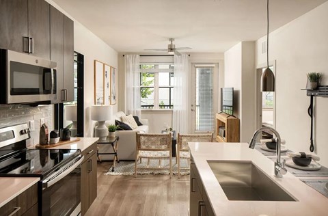 A modern kitchen with a stainless steel sink and wooden floors.