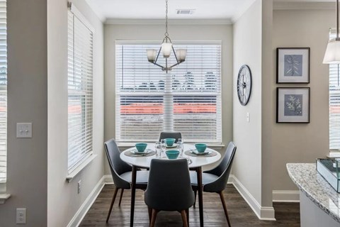 A dining room with a table set for four.