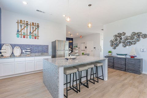 A kitchen with a bar area and a counter with a sink.