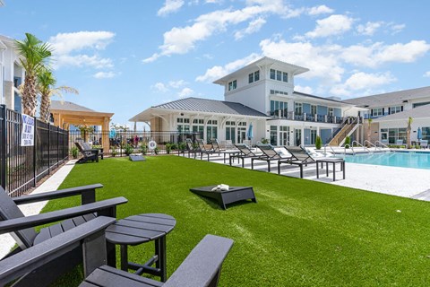 A large white building with a pool in front of it.