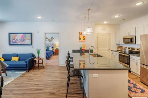 A kitchen with a blue couch and a painting on the wall.