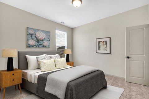 A bedroom with a bed, nightstand, and two lamps.