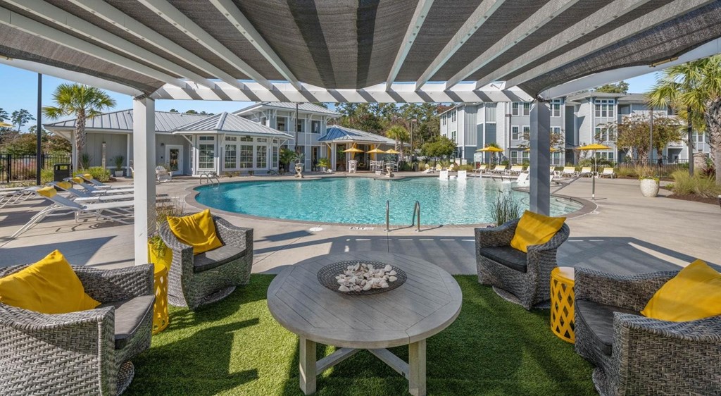 A patio with a table and chairs under a striped awning.