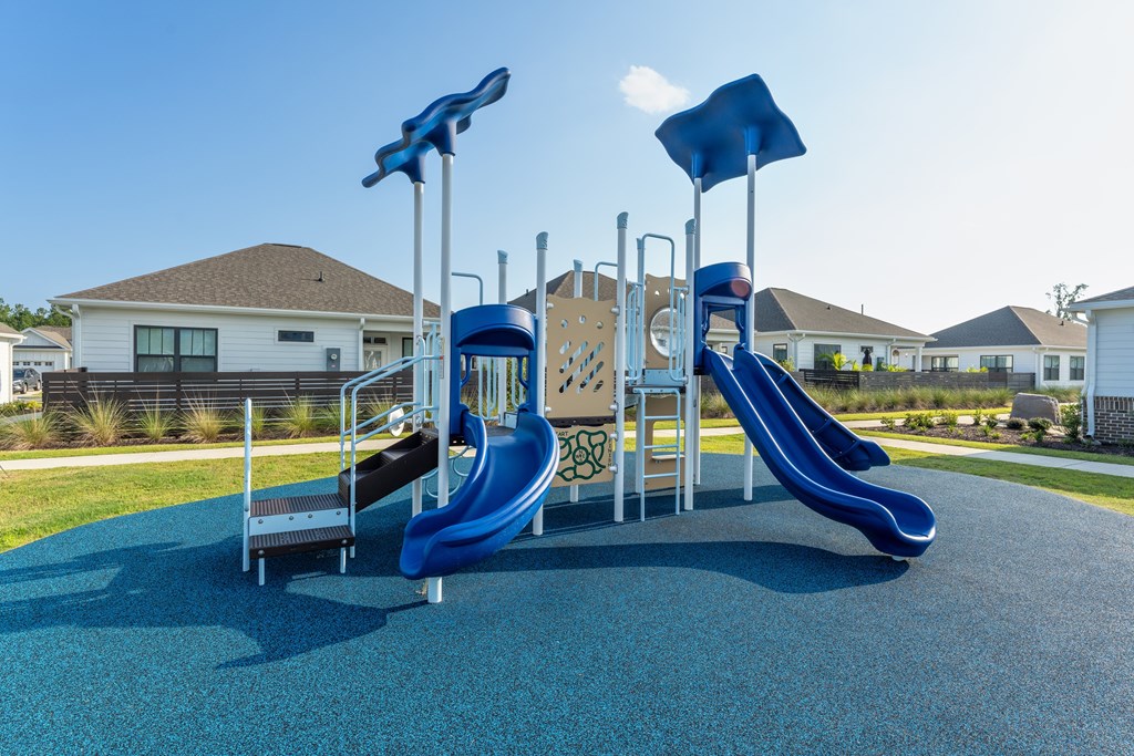 A playground with a blue slide and a yellow slide.