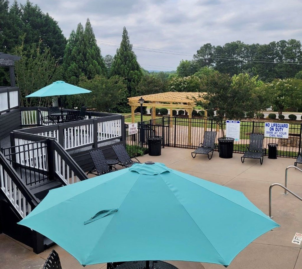 a patio with a turquoise umbrella