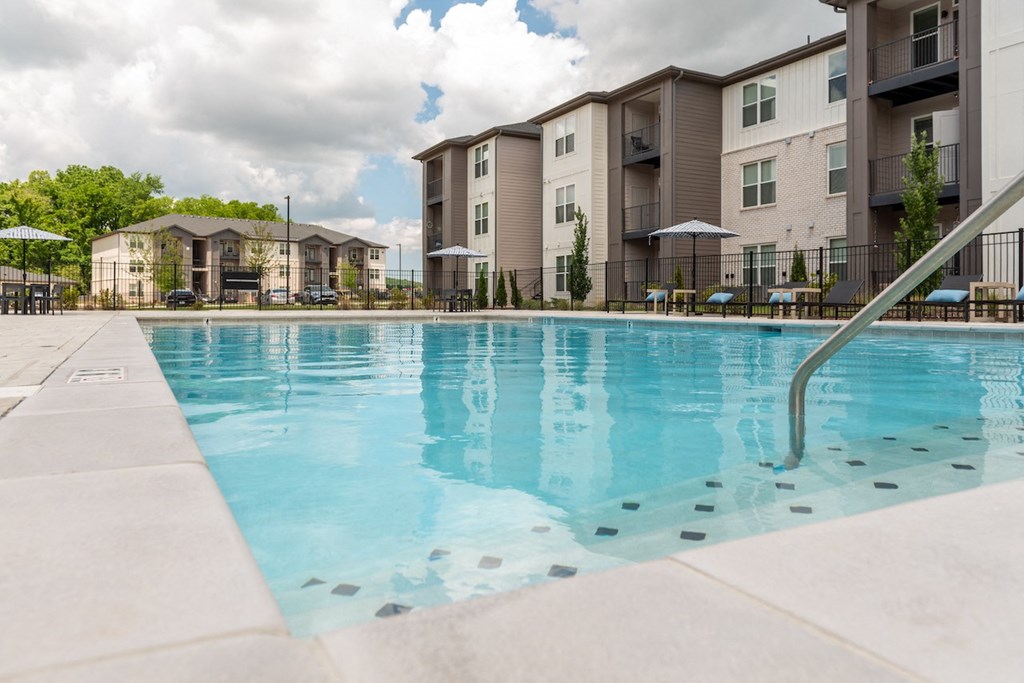 a swimming pool with an apartment building in the background
