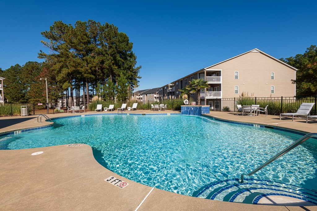 A large swimming pool with a blue tiled edge and a white line in the middle.