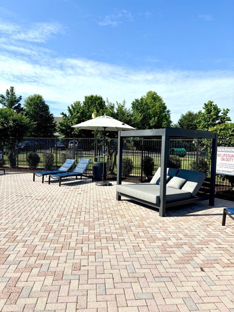 a patio with two lounge chairs and a canopy