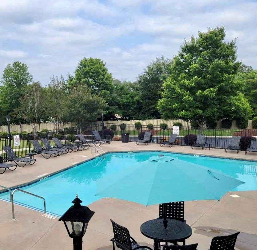 a resort style pool with lounge chairs and umbrellas