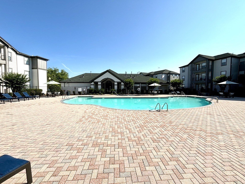 a large swimming pool in front of an apartment building