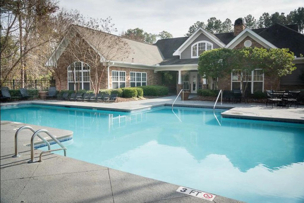 a large swimming pool in front of a house