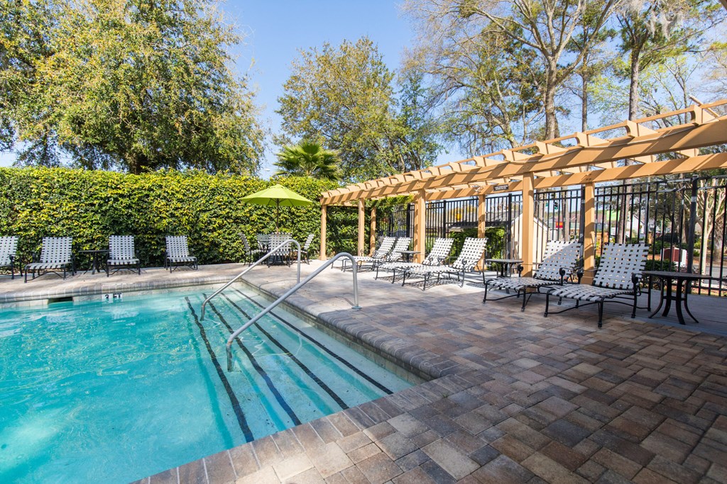 a swimming pool with chairs and a canopy over it