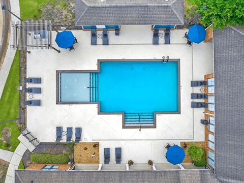 A large swimming pool surrounded by lounge chairs and umbrellas.