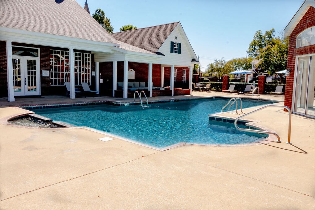 a swimming pool and spa in front of a house