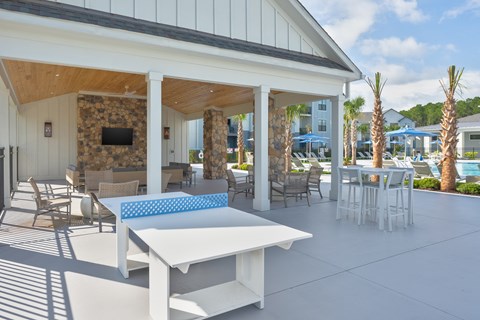 A patio with a white table and chairs at Evolve Holly Ridge Apartments in Holly Ridge, NC.