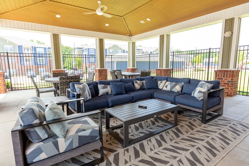 a covered patio with couches and tables
