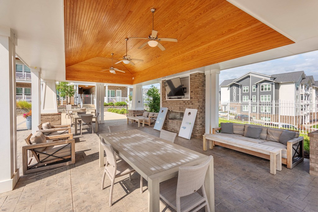 a patio with a wooden ceiling and a table with chairs