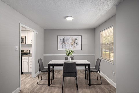 A dining room with a table and chairs.