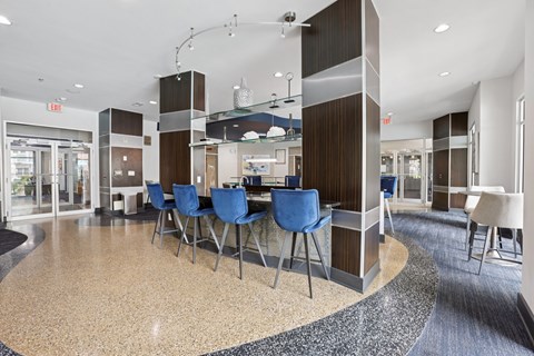 A modern dining area with blue chairs and a circular table.