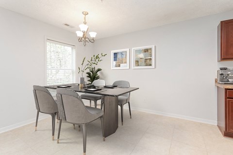A dining room with a table and chairs.