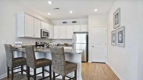 A kitchen with a table and chairs.