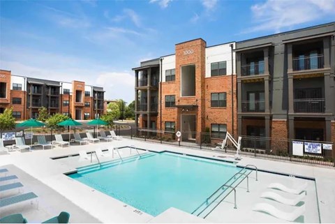A swimming pool in front of apartment buildings.