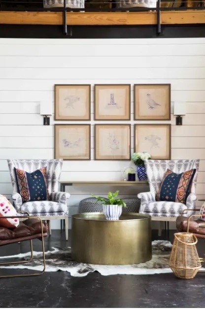 A living room with a white wall and a set of four pictures on it.