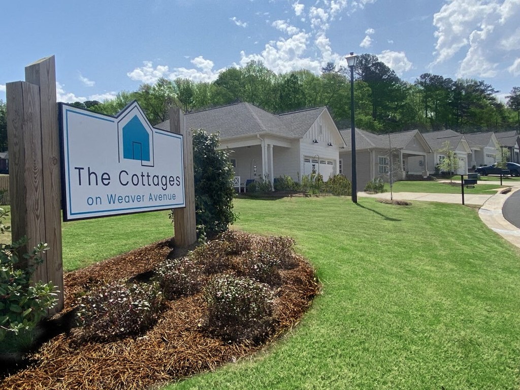 a sign for the cottages on meadow avenue in front of some houses
